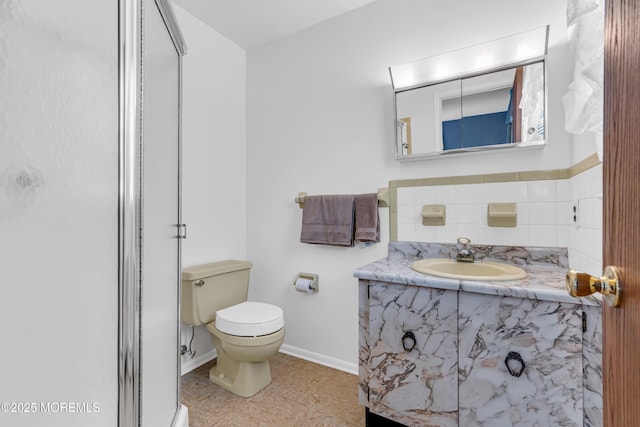 full bathroom featuring vanity, toilet, baseboards, tile patterned floors, and a shower stall