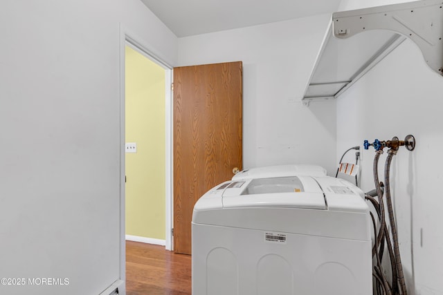 washroom with laundry area, washer and clothes dryer, and wood finished floors