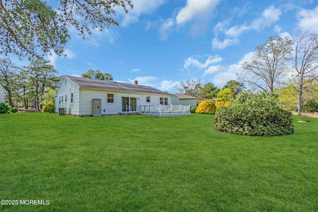 rear view of property with a lawn and a deck