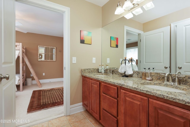 bathroom with a sink, baseboards, and double vanity