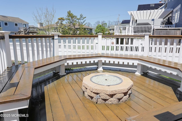 wooden deck featuring a fire pit and a residential view