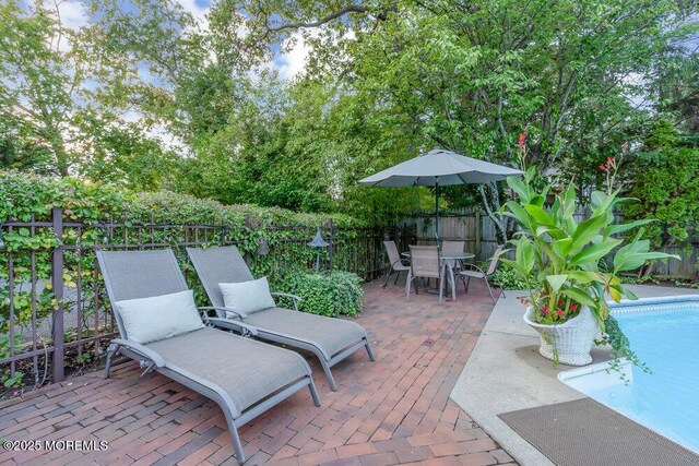 view of patio / terrace with outdoor dining area, a fenced in pool, and a fenced backyard