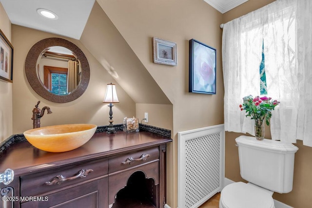 bathroom with radiator heating unit, vanity, and toilet