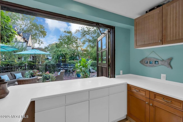 interior space with white cabinetry, light countertops, and brown cabinets