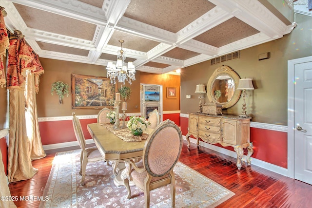 dining space with baseboards, visible vents, hardwood / wood-style flooring, and coffered ceiling