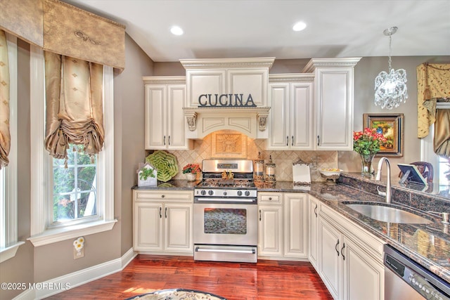 kitchen featuring backsplash, dark wood finished floors, a sink, dark stone countertops, and stainless steel appliances