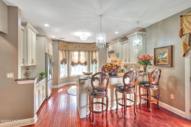 kitchen featuring stainless steel fridge, a peninsula, baseboards, recessed lighting, and dark wood-style floors