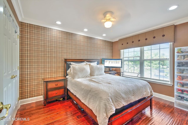 bedroom featuring baseboards, ornamental molding, wallpapered walls, and hardwood / wood-style floors