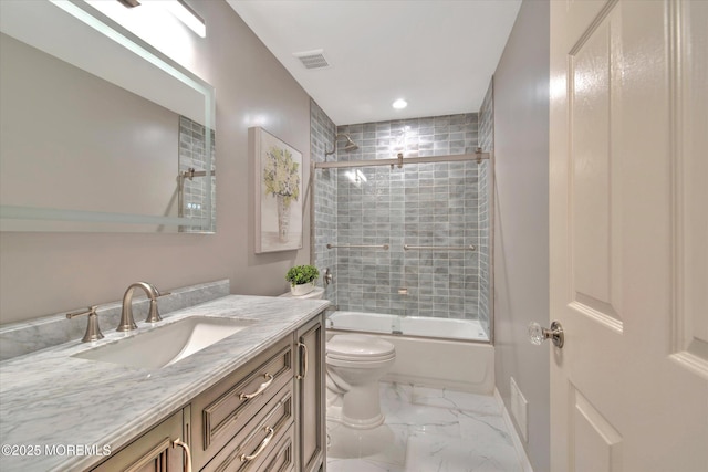 full bath with vanity, toilet, marble finish floor, visible vents, and bath / shower combo with glass door