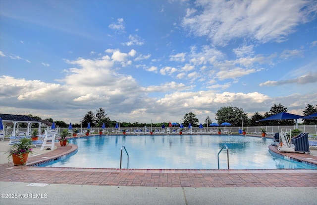 community pool featuring fence and a patio area