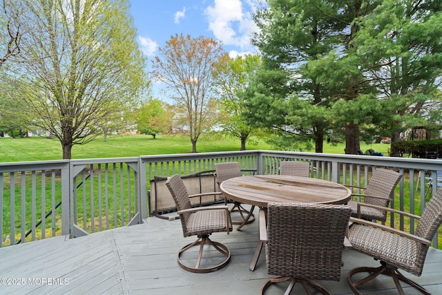 wooden terrace featuring a yard and outdoor dining space