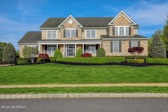 view of front facade with a front lawn and stone siding