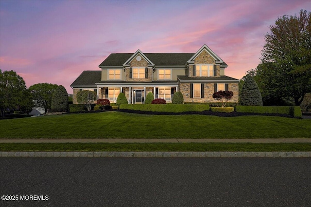 view of front facade featuring a front yard, a porch, and stone siding