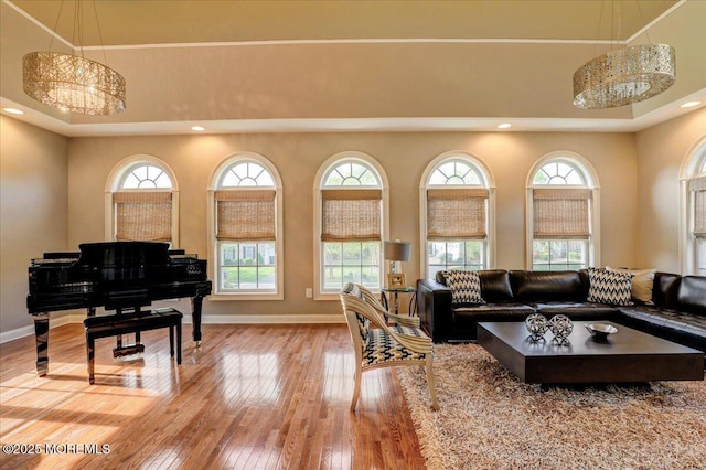 living room with baseboards, a high ceiling, wood-type flooring, and recessed lighting
