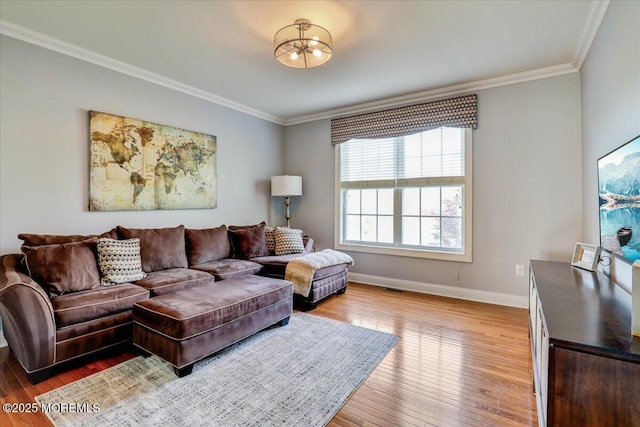 living room featuring baseboards, ornamental molding, wood finished floors, and visible vents