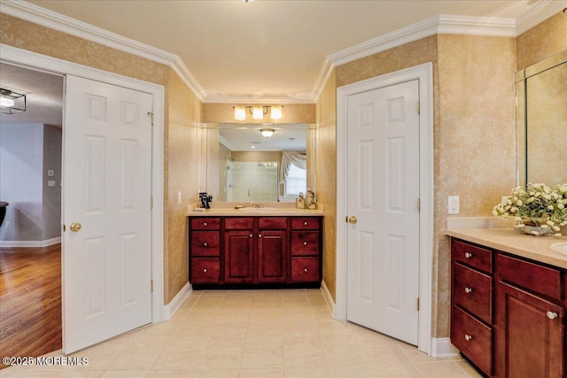 bathroom featuring baseboards, ornamental molding, tile patterned flooring, and vanity