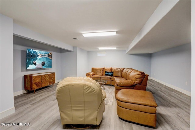 living area with baseboards, wood finished floors, and visible vents