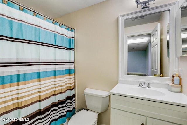 bathroom with toilet, visible vents, a shower with shower curtain, and vanity