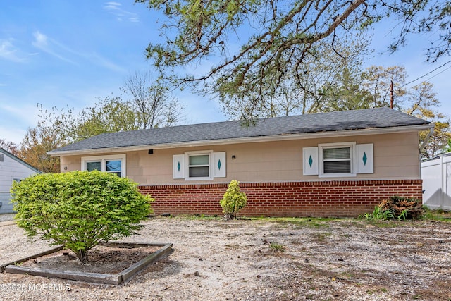 view of front of property featuring roof with shingles and brick siding