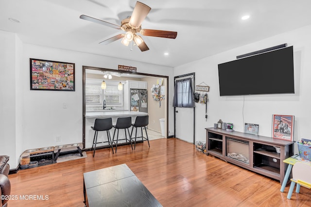 living room with recessed lighting, a ceiling fan, and light wood-style floors