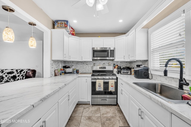 kitchen with tasteful backsplash, stainless steel appliances, white cabinets, and a sink