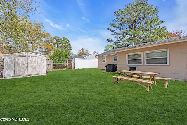 view of yard with an outbuilding, a shed, and a fenced backyard