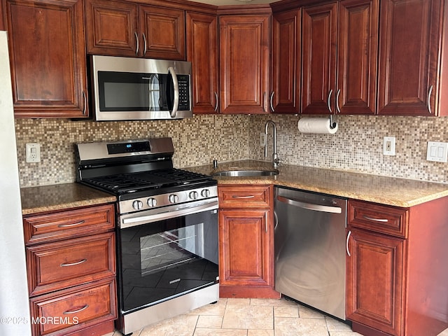 kitchen featuring light tile patterned floors, stainless steel appliances, decorative backsplash, and a sink