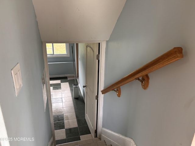 staircase featuring tile patterned floors, vaulted ceiling, and baseboards