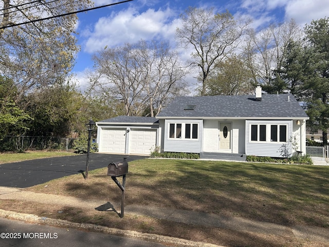 ranch-style home with a chimney, fence, driveway, a front lawn, and an attached garage