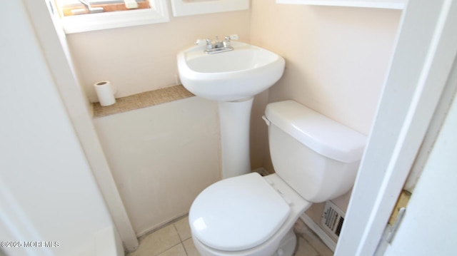 half bath with tile patterned floors and toilet