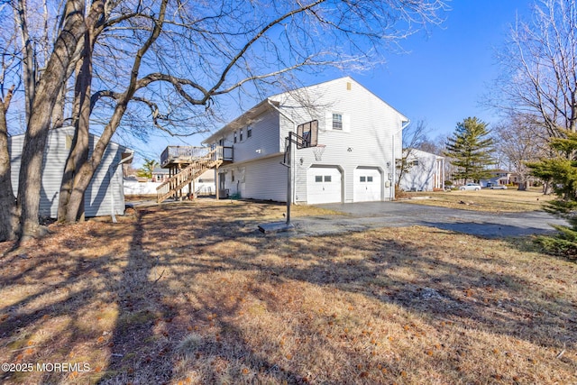 52 Yorke Ct, Freehold, NJ 07728 - view of property exterior with stairway, a deck, an attached garage, and driveway
