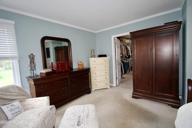 bedroom with a walk in closet, a closet, crown molding, and light carpet