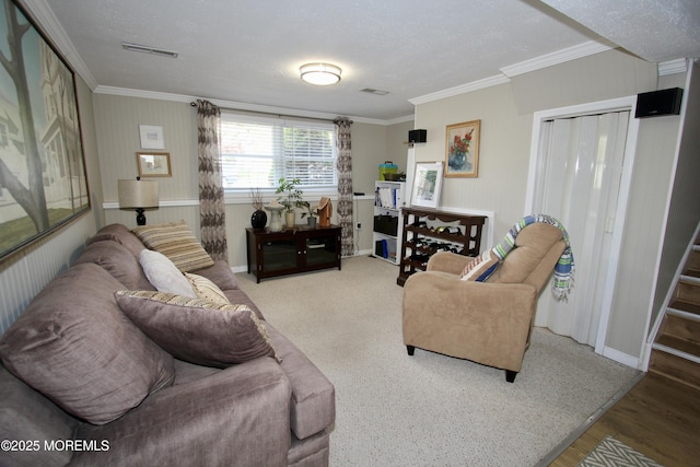 living area featuring wood finished floors, visible vents, crown molding, and baseboards