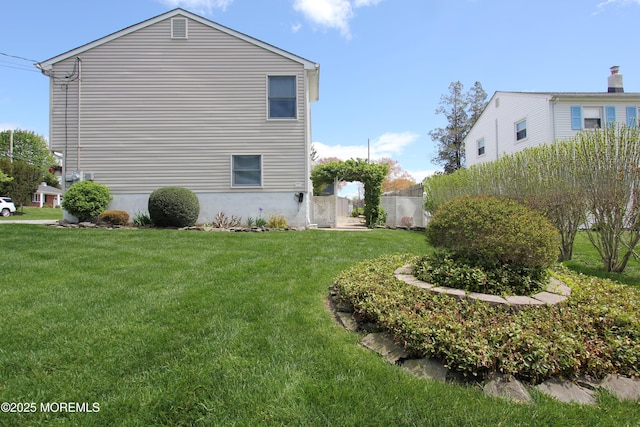 view of side of property with fence and a lawn