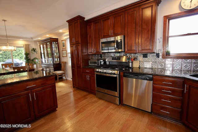kitchen with dark stone counters, recessed lighting, light wood-style flooring, backsplash, and appliances with stainless steel finishes