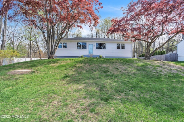view of front of home with fence and a front lawn