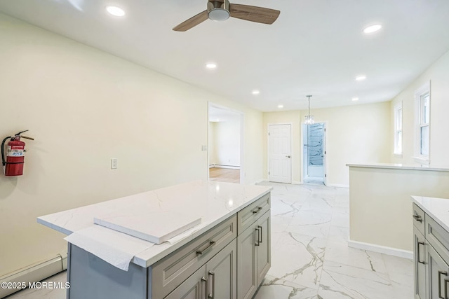 kitchen featuring gray cabinets, recessed lighting, a center island, and marble finish floor