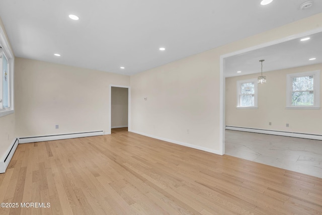 spare room with a baseboard radiator, recessed lighting, light wood-style flooring, and baseboards