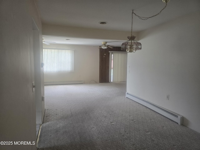 spare room featuring carpet, a ceiling fan, and a baseboard heating unit