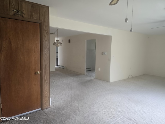 empty room featuring light colored carpet, ceiling fan, and a baseboard radiator