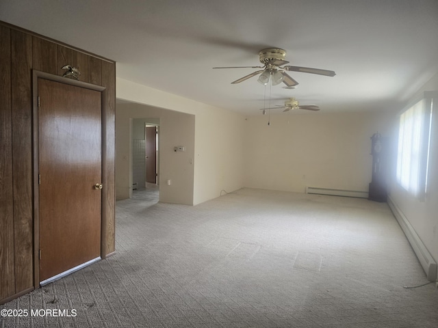 carpeted spare room with a baseboard radiator and a ceiling fan