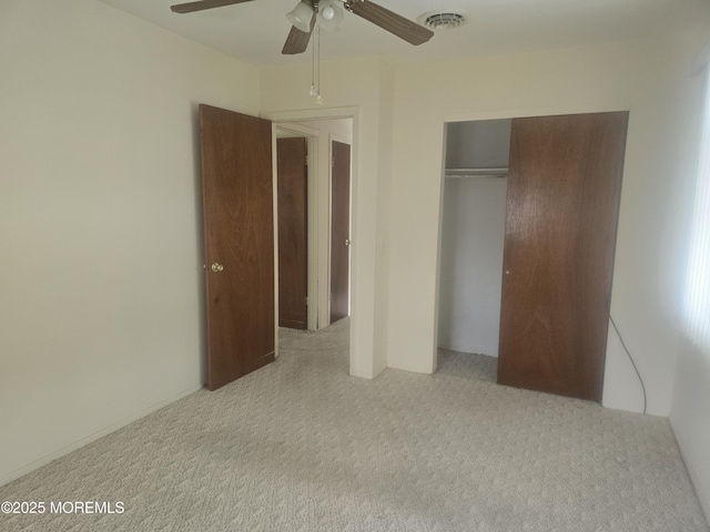unfurnished bedroom featuring visible vents, a ceiling fan, carpet floors, and a closet