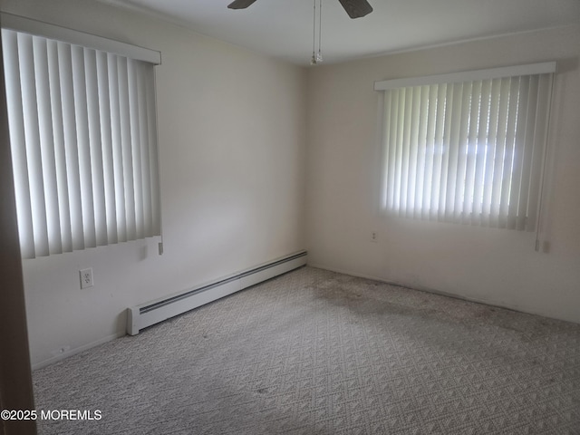 carpeted spare room featuring a ceiling fan and a baseboard radiator