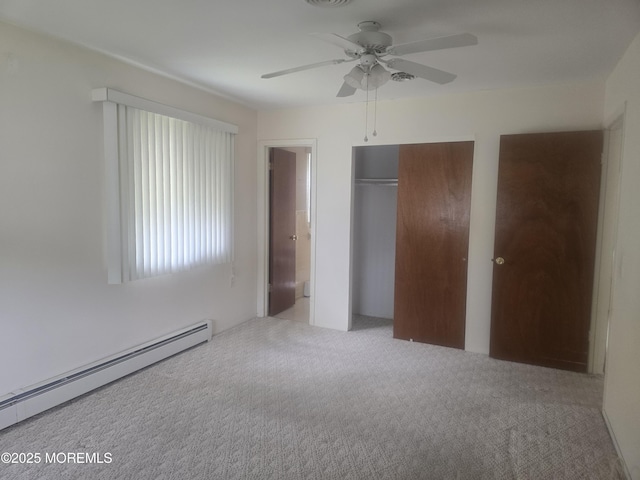 unfurnished bedroom with visible vents, baseboard heating, carpet, multiple closets, and a ceiling fan