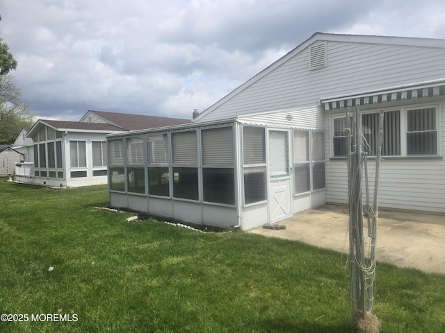 rear view of house with a yard and a sunroom