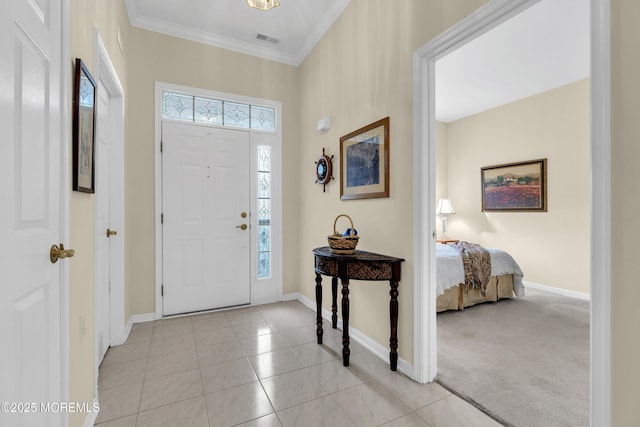 entrance foyer with crown molding, baseboards, light tile patterned floors, and visible vents