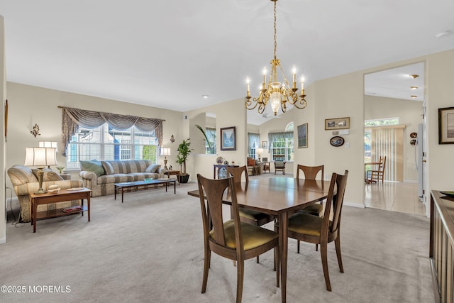 dining area with light colored carpet, baseboards, and a chandelier