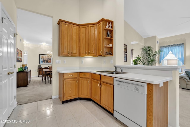 kitchen featuring light carpet, light countertops, a sink, dishwasher, and a notable chandelier