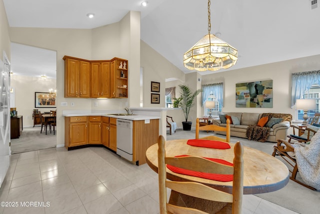 dining space with baseboards, light tile patterned floors, a notable chandelier, and high vaulted ceiling