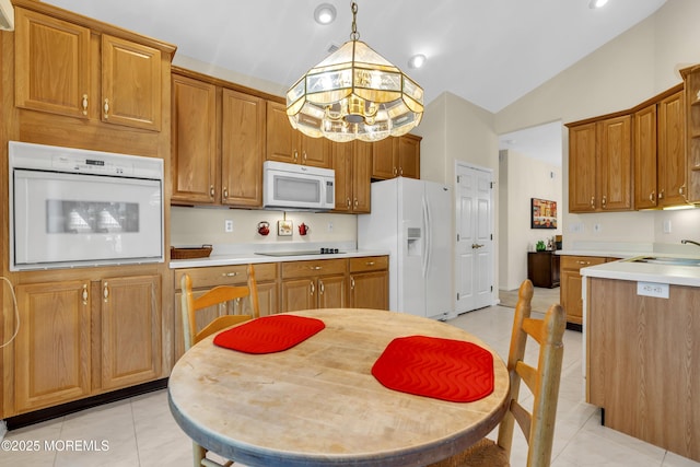 kitchen with light countertops, light tile patterned floors, brown cabinets, and white appliances